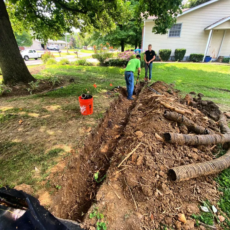 Sugarloaf crew digging a drainage line across a front yard